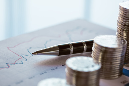 Stack of coin with financial line chart and penの写真素材