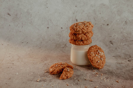 Oatmeal cookies with milk on light background with crumbsの写真素材