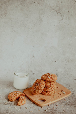 Oatmeal cookies with milk on light background with crumbsの写真素材