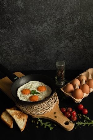 Fried glaze eggs in a frying pan on a black background