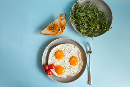 Fried eggs in a plate on a blue backgroundの写真素材