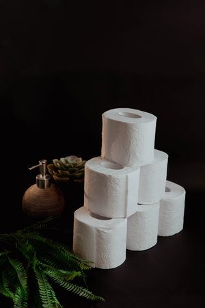 Stack of toilet paper rolls on black backgroundの写真素材