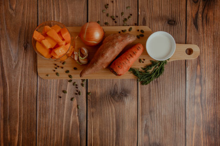 Ingredients: vegetables for pumpkin soup on a wooden tableの写真素材