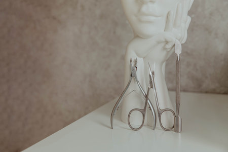 Manicure tools on a light background with a sculptural vaseの写真素材