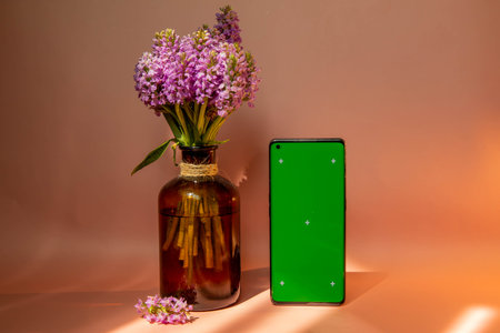 Chroma key on phone with bouquet of flowers on pink backgroundの写真素材