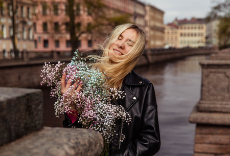 Girl in black leather jacket with pink flowersの写真素材