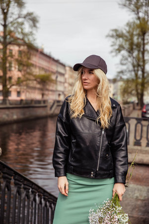 Girl in black cap and leather jacket with pink flowersの写真素材