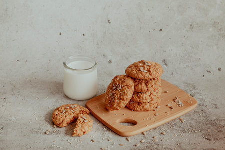 Oatmeal cookies with milk on light background with crumbsの写真素材