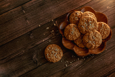 Oatmeal cookies on a dark wooden background with crumbsの写真素材