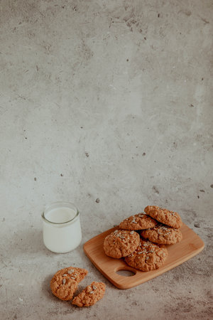 Oatmeal cookies with milk on light background with crumbsの写真素材