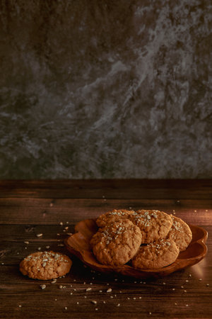 Oatmeal cookies on a dark wooden background with crumbsの写真素材