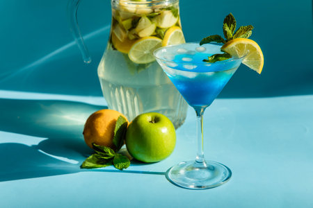Homemade lemonade with lemon, mint and apple on a blue backgroundの写真素材