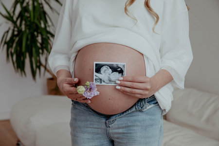 Pregnant belly and close-up ultrasound of baby embryo.の写真素材