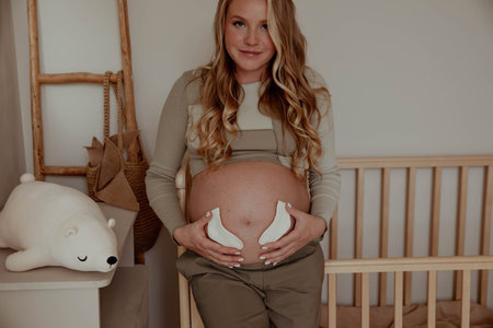 Pregnancy, family, love, woman holding tiny socks for baby.の写真素材