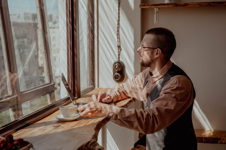 Man with glasses by the window working at a computer on a sunny day. high quality photo
