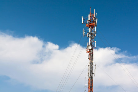 Telecommunication tower with antenna against blue sky
