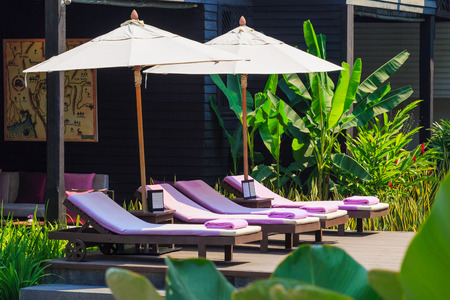 Outdoor pool chair in resort garden, Thailandの写真素材