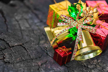 Christmas decoration with red ornament, gift box, bell on wooden backgroundの写真素材