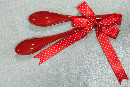 christmas spoon with red polka dot ribbon on glitter paper backgroundの写真素材