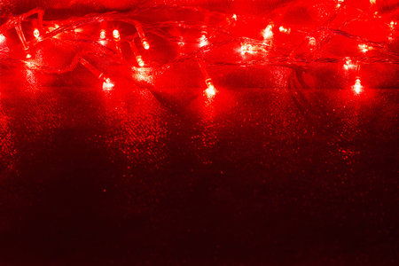 red christmas lights on twinkled fabric background