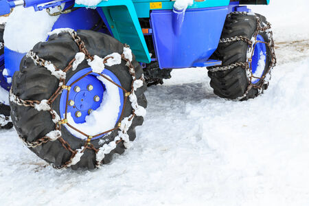 wheel with chain of small excavator on iceの写真素材