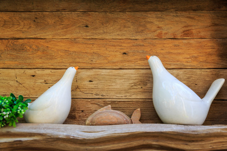 Ceramic bird on wooden frame backgroundの写真素材