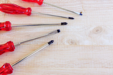 Red screwdrivers on wooden background
