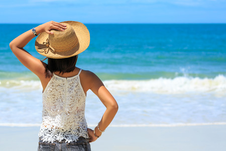 Back view of Travel asia woman with hat looking out of sea on a beach in summer, Koh Samet, Thailandの写真素材