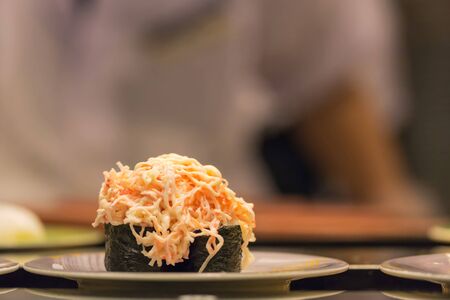 Japanese sushi roll (gunkan maki)with Crab stick salad and seaweed on dishの写真素材