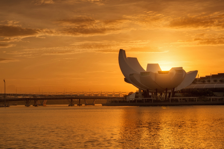 SINGAPORE - FEB 24, 2016: Silhouette of Singapore city skyline with Artscience Museum in Marina bay at sunriseのeditorial素材