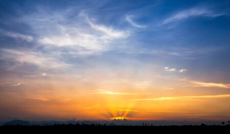Sunset sky and cloud with silhouette of land and palm tree backgroundの写真素材