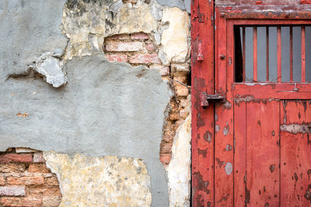 Old red wooden door with grunge cement and brick wall background