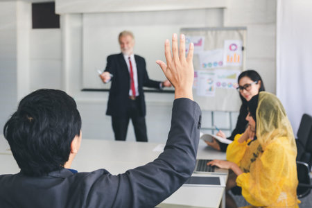 Business man hand up for asking questions in meeting, business training class conceptの写真素材