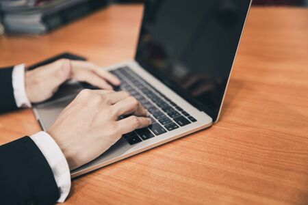 Business man using laptop in modern office, vintage styleの写真素材