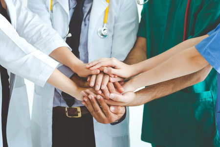 Group of happy doctor surgeon and nurse putting their hands together for teamwork in meeting on white background, Healthcare and medical conceptの写真素材
