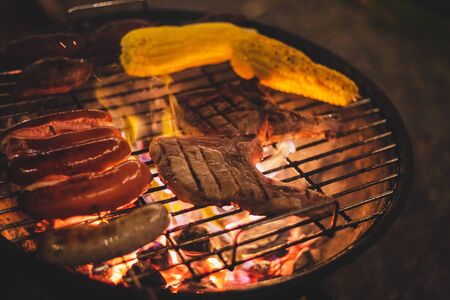 Family making barbecue in dinner party camping at nightの写真素材