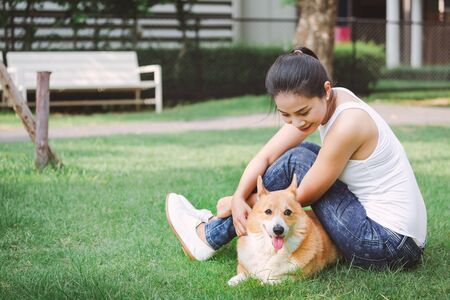 Portrait of asian woman with dog Welsh Corgi Pembroke in dog parkの写真素材