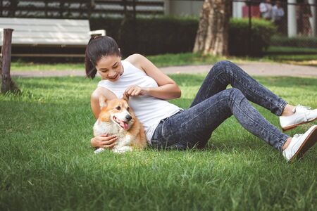 Portrait of asian woman with dog Welsh Corgi Pembroke in dog parkの写真素材