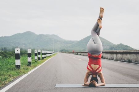 Asia woman with sport bra doing yoga fitness exercise for relax and healthy at lake in morning, Nature background, Concept outdoor sport and healthの写真素材