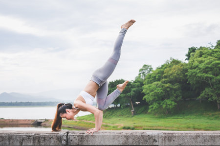 Asia woman with sport bra doing yoga fitness exercise for relax and healthy at lake in morning,...