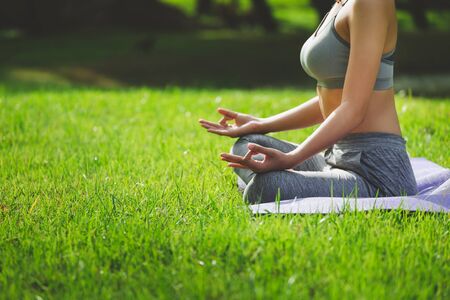 Fitness asian woman doing yoga exercise and relax with sportswear in green park at summer, healthy lifestyle conceptの写真素材