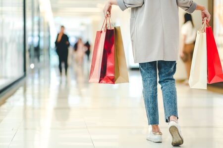 Lifestyle shopping concept, Young happy asian woman with paper bag and coat in shopping mall, vintage styleの写真素材