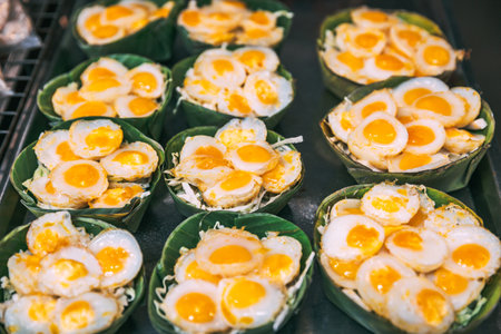 Thai street food concept, Fried quail egg in banana leaf tray at traditional shopping street market in Bangkok Thailandの写真素材