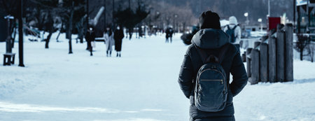 Travel winter concept, Traveler asian woman or photographer with backpack against snow in winter season at Toya city, Hokkaido, Japanの写真素材