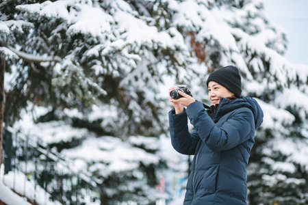 Travel woman or photographer with backpack and camera against snow in winter season at sapporo city,...