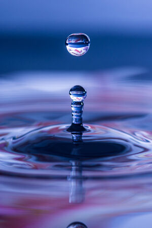 Splash rising from the water s surface after impact of water dropletの写真素材