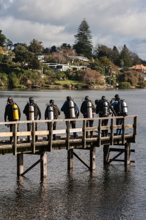 group of scuba divers on jetty on lake Pupukeの写真素材