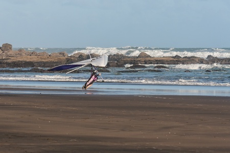 hang glider landing on beachの写真素材