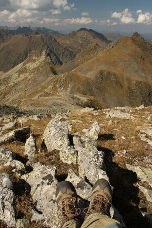 detail of walking boots with mountains in backgroundの写真素材
