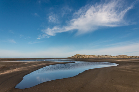 blue sky reflecting in pool on Whatipu beachの写真素材